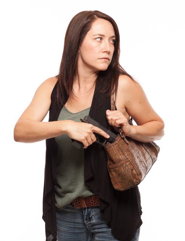 Woman looking to her left pulling a gun out of her purse